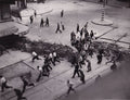DOISNEAU (Robert). | Groupe de FFI et de civils courant derrière une barricade dressée à l'angle de la rue Saint-Jacques et du boulevard Saint-Germain. Photographie originale en tirage d'époque.